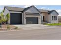 Well-manicured front exterior showcasing a brick facade, a two-car garage, and tasteful landscaping at 1425 Burt Ave, Berthoud, CO 80513