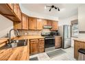 Well-lit kitchen features wood cabinetry, stainless steel appliances, and a modern tile backsplash at 1240 S Idalia St, Aurora, CO 80017