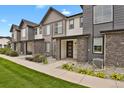 Modern townhome exterior showcasing stone accents, neutral siding, covered entry, and landscaped front yard for curb appeal at 19733 W 93Rd Ln # D, Arvada, CO 80007