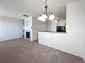Spacious living room featuring a fireplace, chandelier, and open view to the kitchen area at 12713 Leyden St # E, Thornton, CO 80602