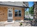 Inviting townhouse entrance with brick facade, decorative bench, and well maintained landscaping at 1537 S Owens St # 31, Denver, CO 80232