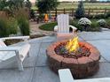 Inviting backyard with a stone fire pit, Adirondack chairs, and landscaped surroundings, perfect for outdoor relaxation at 800 Meadowlark Dr, Erie, CO 80516