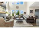 Bright living room boasts soaring ceilings, many windows, a fireplace, and comfortable seating at 800 Meadowlark Dr, Erie, CO 80516