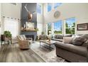 Bright living room features a cozy fireplace, high ceilings, and large windows offering picturesque views at 800 Meadowlark Dr, Erie, CO 80516