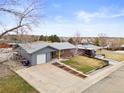 An aerial view showing the brick home, surrounding neighborhood, and mature trees at 6671 Chase St, Arvada, CO 80003
