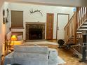 Comfortable living room with a stone fireplace, wood floors, and staircase to upper level at 6836 W 84Th Cir # 15, Arvada, CO 80003