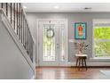 Inviting foyer featuring hardwood floors, stylish staircase, and decorative glass front door at 3330 E Tennessee Ave, Denver, CO 80209