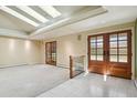 Bright entryway with skylights, double front doors, neutral carpet, and white tile flooring at 5460 S Locust St, Greenwood Village, CO 80111