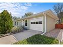 Side view of the property showcasing a well-maintained one-car garage with a white door at 1650 Bedivere Cir, Lafayette, CO 80026