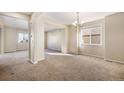 Bright open-concept living room with neutral carpet, chandelier, and ample natural light at 21383 E Smoky Hill Rd, Centennial, CO 80015