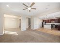 Open floor plan with carpeted living room, staircase, and hardwood kitchen with dark cabinetry at 21383 E Smoky Hill Rd, Centennial, CO 80015