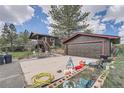 The exterior features a 2-car garage, spacious driveway, and landscaped front yard at 7715 Rafter Rd, Franktown, CO 80116