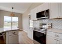 Bright kitchen featuring white cabinets, stainless steel appliances, and modern finishes at 34544 Columbine W Trl, Elizabeth, CO 80107