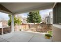 Relaxing covered patio with a beautiful tree lined backyard and privacy fence at 9640 Sydney Ln, Highlands Ranch, CO 80130
