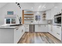 Updated kitchen with white subway tile, white cabinets, wood shelves, and stainless steel appliances at 32187 Sylvan Rd, Golden, CO 80403