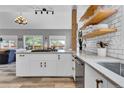 Bright kitchen featuring light wood floors, white cabinets, open shelving, and mountain views at 32187 Sylvan Rd, Golden, CO 80403