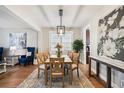 Bright dining room featuring a modern light fixture, stylish decor, and hardwood floors at 8720 E 29Th Ave, Denver, CO 80238