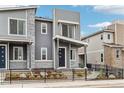 Modern townhouse with gray siding and stone accents, surrounded by landscaping at 4588 S Versailles St # B, Aurora, CO 80015