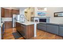 Modern kitchen with stainless steel appliances, island sink, and open living room concept at 1017 Mircos St, Erie, CO 80516