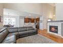 Spacious open concept living area featuring a fireplace, wood floors, and seamless kitchen access at 1017 Mircos St, Erie, CO 80516