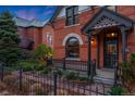 Close-up of a home's brick exterior, front porch, and manicured landscaping at 2815 Curtis St, Denver, CO 80205