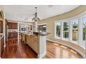 Bright, spacious kitchen with custom cabinets, center island, granite countertops, and hardwood floors at 81 Falcon Hills Dr, Highlands Ranch, CO 80126