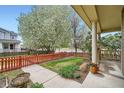 Charming front yard with a beautiful blossoming tree, red picket fence, and covered front porch at 2538 Central Park Boulevard, Denver, CO 80238