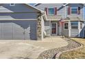 Shows the front of a gray home featuring a 2-car garage, and stone accents at 11042 Blackwolf Ln, Parker, CO 80138