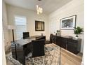 Stylish home office with modern black desk, decor, and ample natural light at 5492 Woodroot Pt, Castle Rock, CO 80104