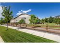 Landscaped backyard featuring a wooden fence, grass, and trees, creating a private outdoor space at 26722 E Peakview Pl, Aurora, CO 80016