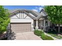 Charming home with a two-car garage, covered porch, and manicured landscaping under a bright blue sky at 6187 Reed Way, Arvada, CO 80003