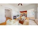 Open-concept living room with fireplace flowing into the kitchen, creating a seamless space for entertaining at 6187 Reed Way, Arvada, CO 80003