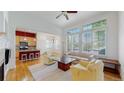 Bright living room flows into kitchen with hardwood floors, and a ceiling fan above at 6187 Reed Way, Arvada, CO 80003