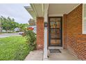 Home featuring a secure black metal door, a lush rose bush, and green lawn at 1325 Geneva St, Aurora, CO 80010