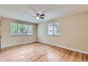 Bright living room with hardwood floors, ceiling fan, and plenty of natural light from the windows at 1325 Geneva St, Aurora, CO 80010