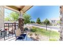 Inviting front porch with comfortable seating, decorative stone columns, and a view of the neighborhood at 4718 Raven Run, Broomfield, CO 80023