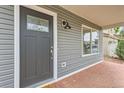 Close up of home's front door, brick entryway, and stylish exterior light fixture at 5120 Perth St, Denver, CO 80249