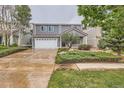 Traditional two-story home with grey siding, two-car garage, and professionally landscaped front yard at 5120 Perth St, Denver, CO 80249