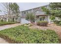 Two-story home with a two-car garage, a manicured lawn, and mature landscaping at 5120 Perth St, Denver, CO 80249