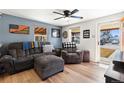 Comfortable living room with modern ceiling fan, wood floors, and an open front door at 6835 W 55Th Pl, Arvada, CO 80002