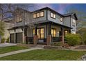 Charming two-story home with a covered front porch, landscaped lawn, and a two-car garage at 10938 Mcclellan Rd, Parker, CO 80134