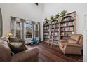 Cozy living room featuring a bookcase with library ladder, hardwood floors and neutral tones at 10938 Mcclellan Rd, Parker, CO 80134