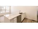 Stylish kitchen island featuring a stainless steel dishwasher and undermount sink at 2002 S Haleyville Way, Aurora, CO 80018