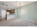 Open living area with modern lighting, neutral colors, and access to the kitchen at 2575 S Syracuse Way # H106, Denver, CO 80231