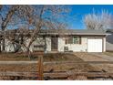 House exterior showcasing a front yard, driveway, and mature trees at 1331 4Th St, Fort Lupton, CO 80621