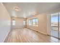 Bright and airy living room featuring wood floors, neutral walls, recessed lights, and access to deck at 6646 Merrimack Dr, Castle Pines, CO 80108