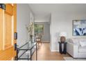 Inviting entryway with light gray walls, hardwood floors, and a glimpse into the dining area at 4182 W Quinn Pl, Denver, CO 80236