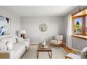 Cozy living room with a bay window, a comfortable sofa, and a decorative mirror at 4182 W Quinn Pl, Denver, CO 80236
