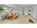 Comfortable living room featuring a leather sofa, wood floors, and modern decor leading to hallway and bedrooms at 1173 Xenon St, Golden, CO 80401