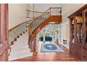 Grand foyer with a sweeping staircase and hardwood floors creates a stunning entrance at 11406 Conifer Ridge Dr, Conifer, CO 80433